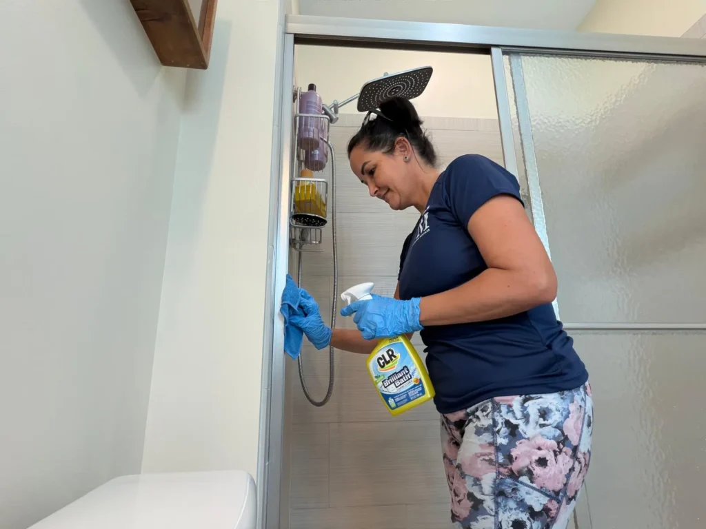 Cleaning Services GM crew member sanitizing a shower during a house cleaning in the Florida Keys